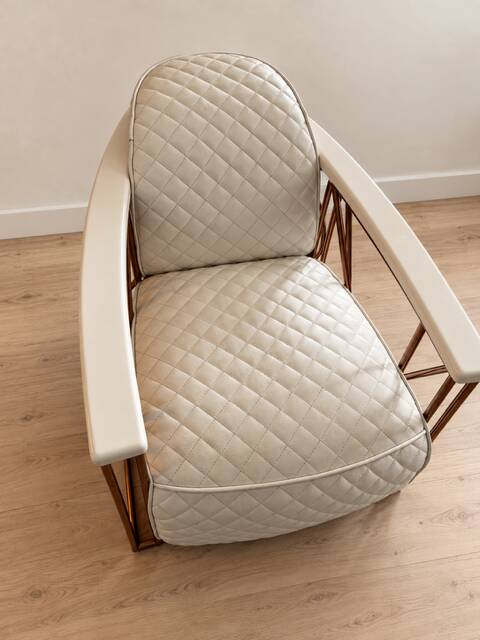 ENNIO armchair in quilted white leather with a copper stainless steel frame.