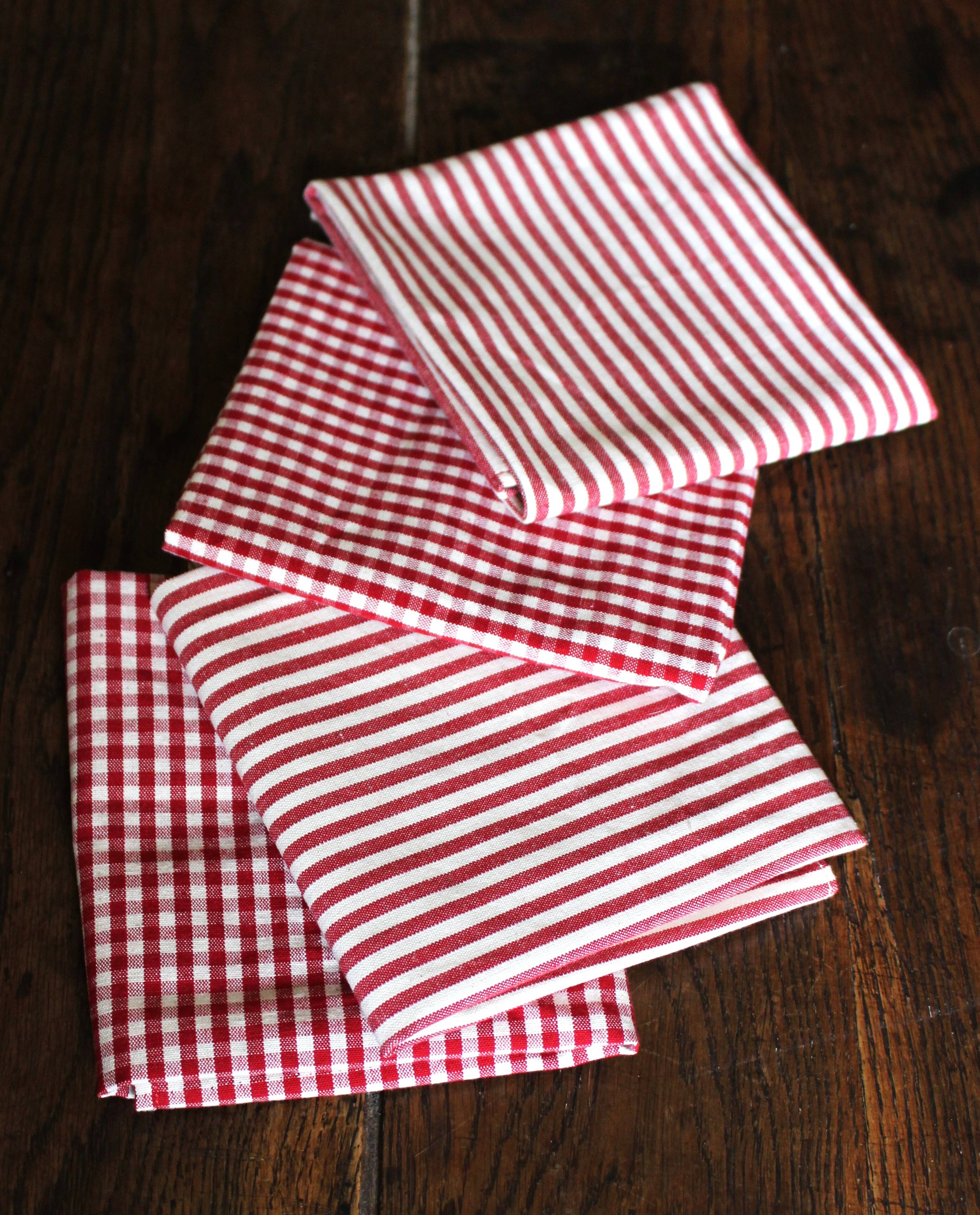 A set of 4 red striped and checkered napkins.