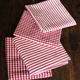 A set of 4 red striped and checkered napkins.
