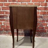 Wooden bedside table topped with a pink marble top