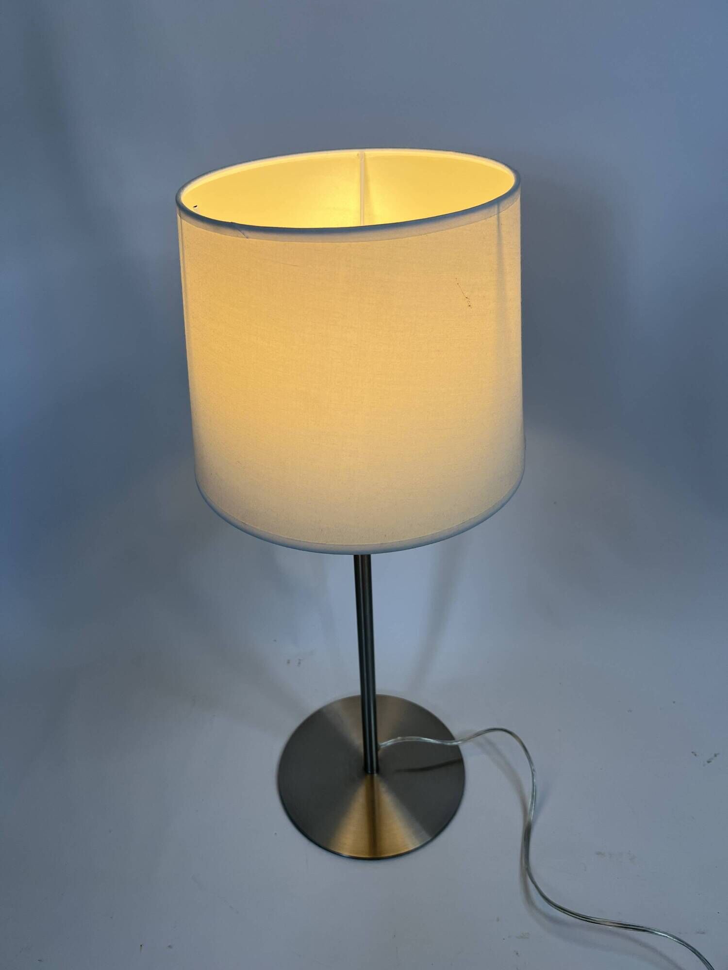 Pair of large brushed metal lamps with cream shades.