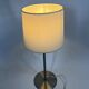 Pair of large brushed metal lamps with cream shades.