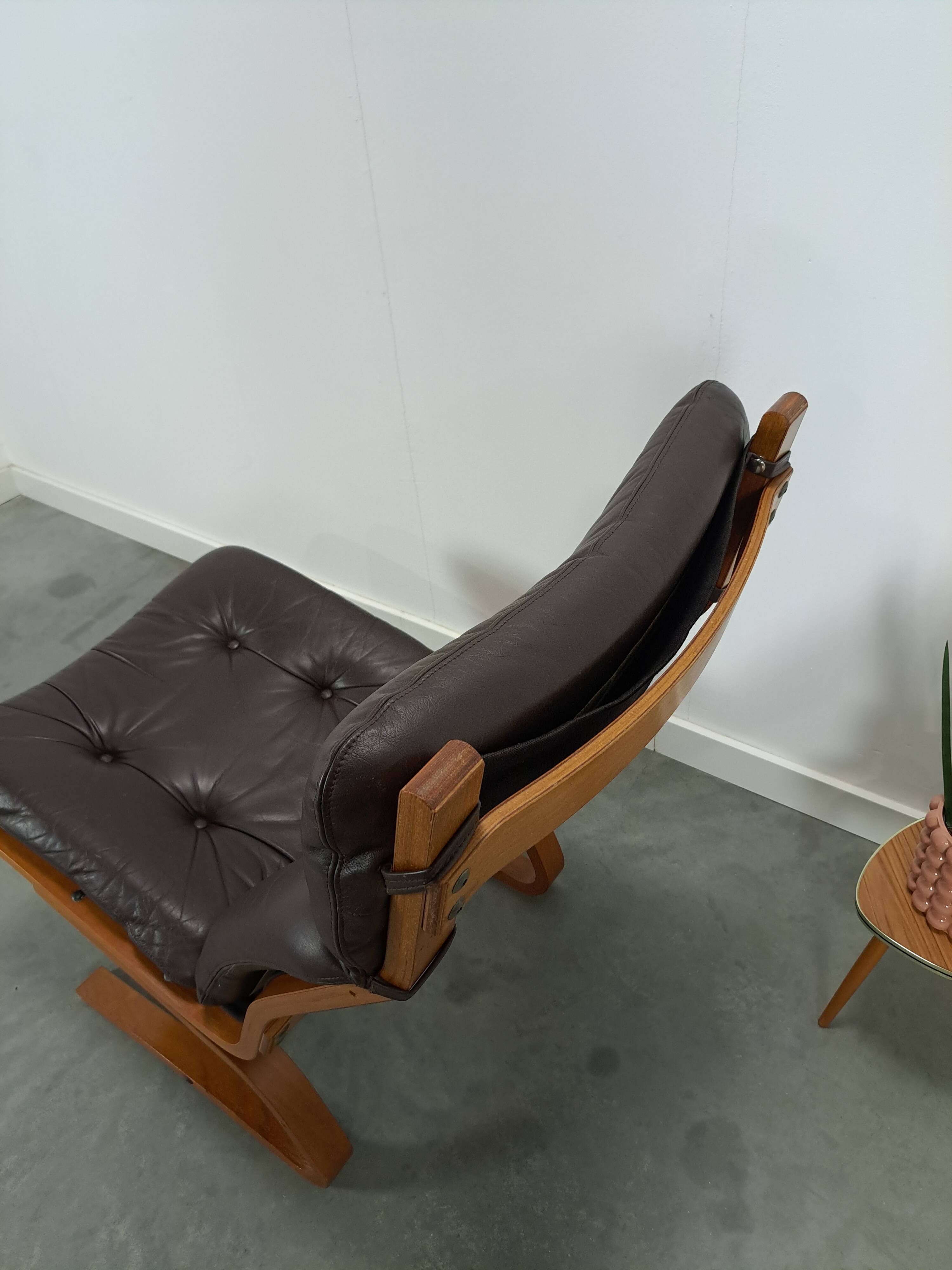 Bruin leren fauteuil met houten onderstel