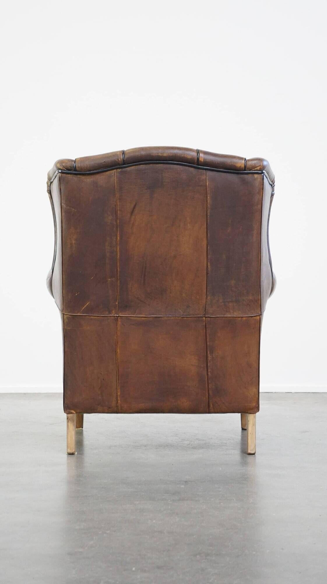 Wing chair made of sheepskin and neatly finished with black piping