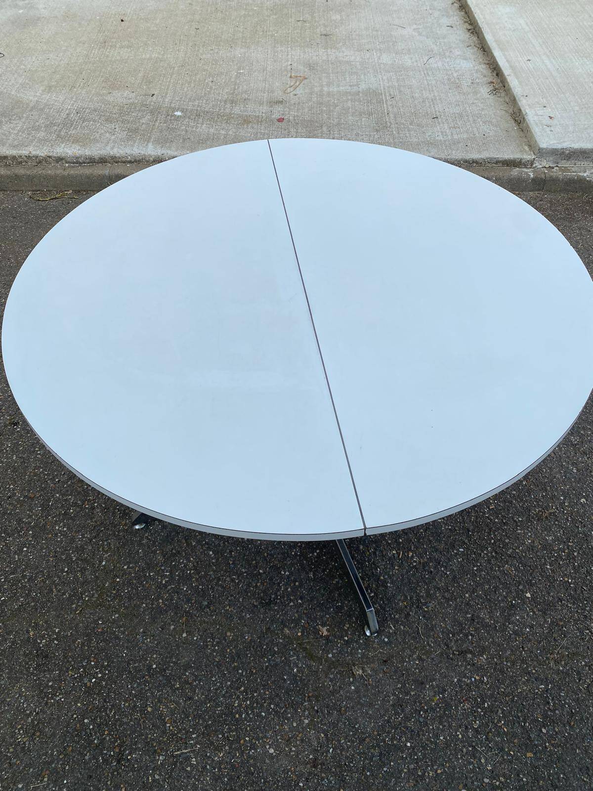 White dining table with a central pedestal, extendable, from the 1970s.