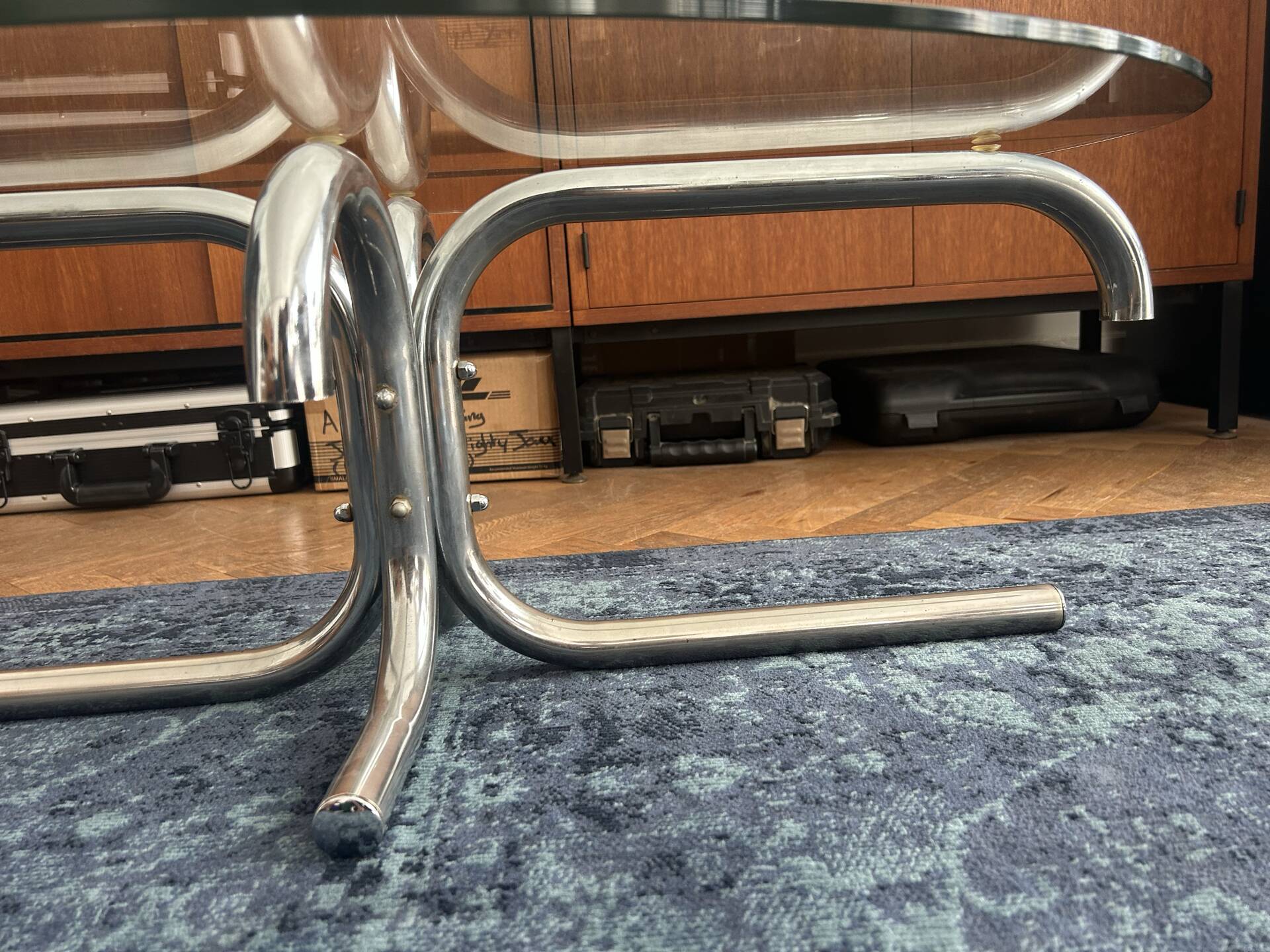 Oval glass coffee table with chrome legs, vintage 70s design.