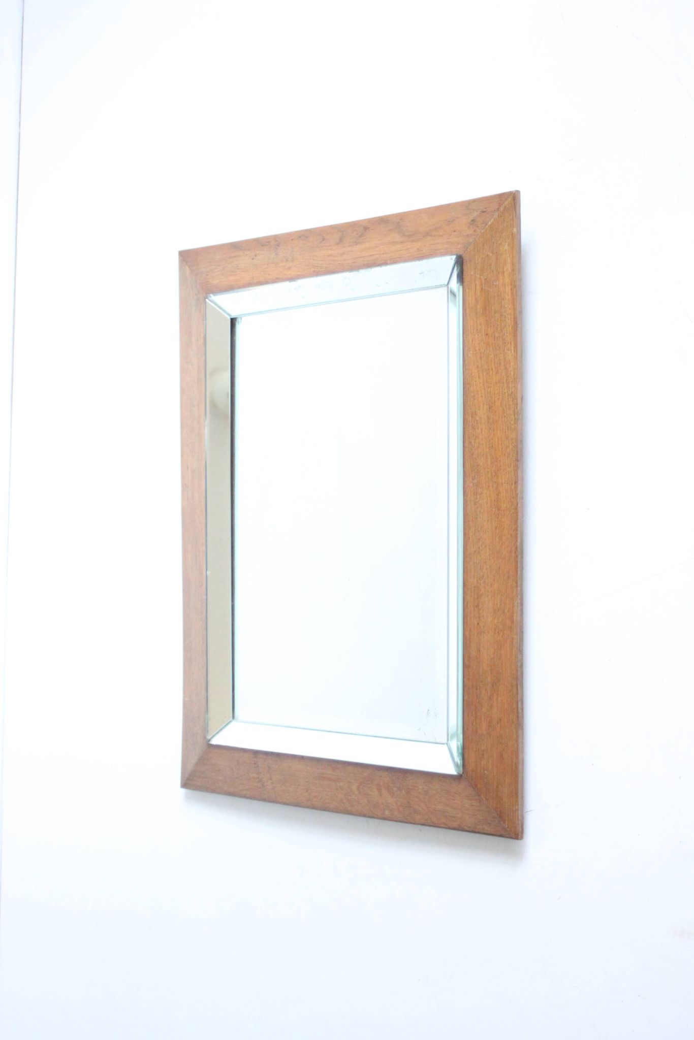 Art deco beveled mirror in an oak frame, 1940s.
