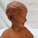Terracotta bust of a smiling little boy.