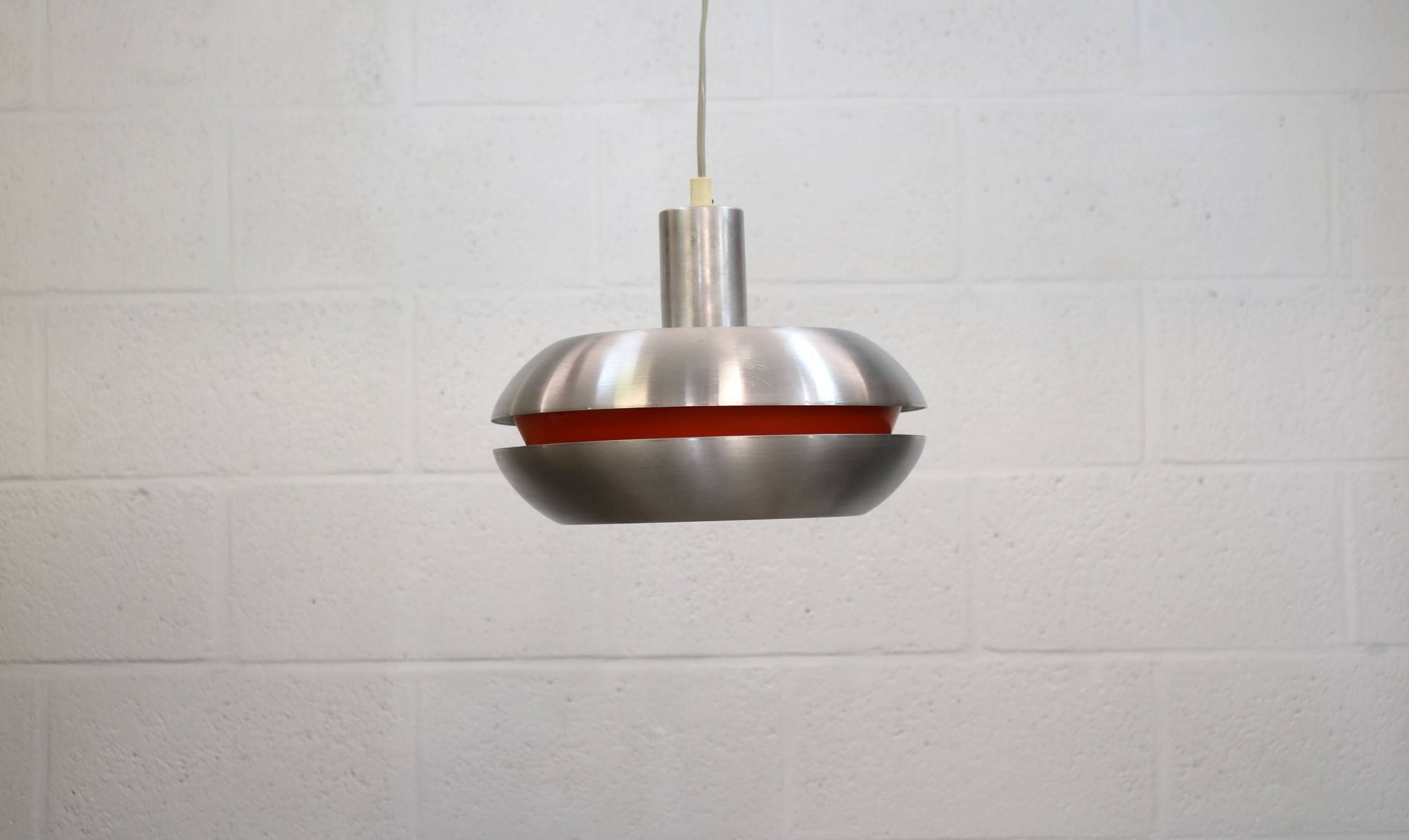 Ancienne lampe de design danois de l'ère spatiale en aluminium avec intérieur orange.