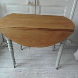 Walnut table with raised flaps, base on verdigris casters.