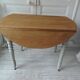 Walnut table with raised flaps, base on verdigris casters.