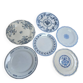 A lot of mismatched old blue plates.