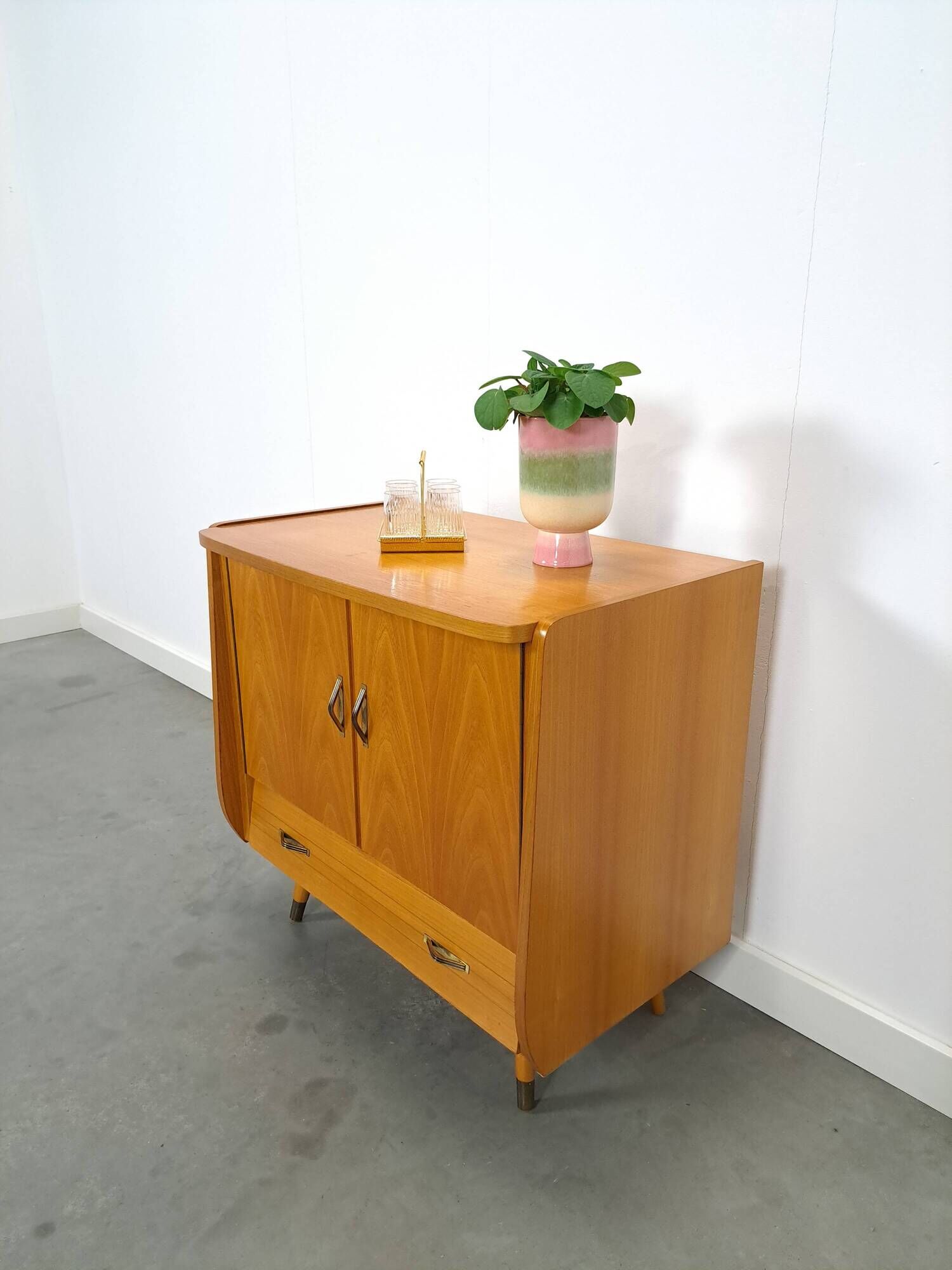 Meuble TV audio avec poignées en laiton et pieds inclinés.
