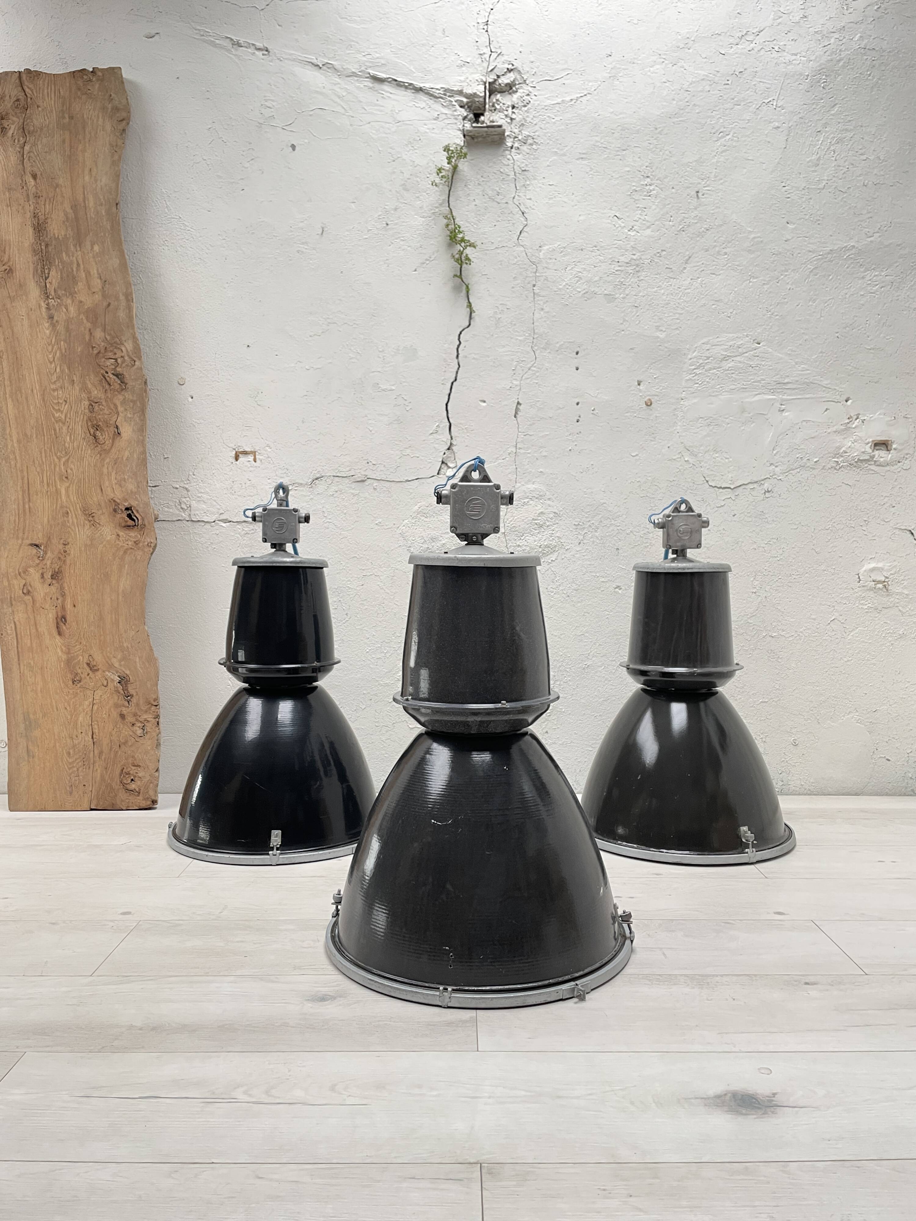 Suite de trois lampes industrielles.
