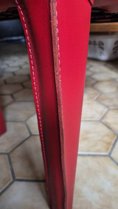 Red leather dining chairs by Arper