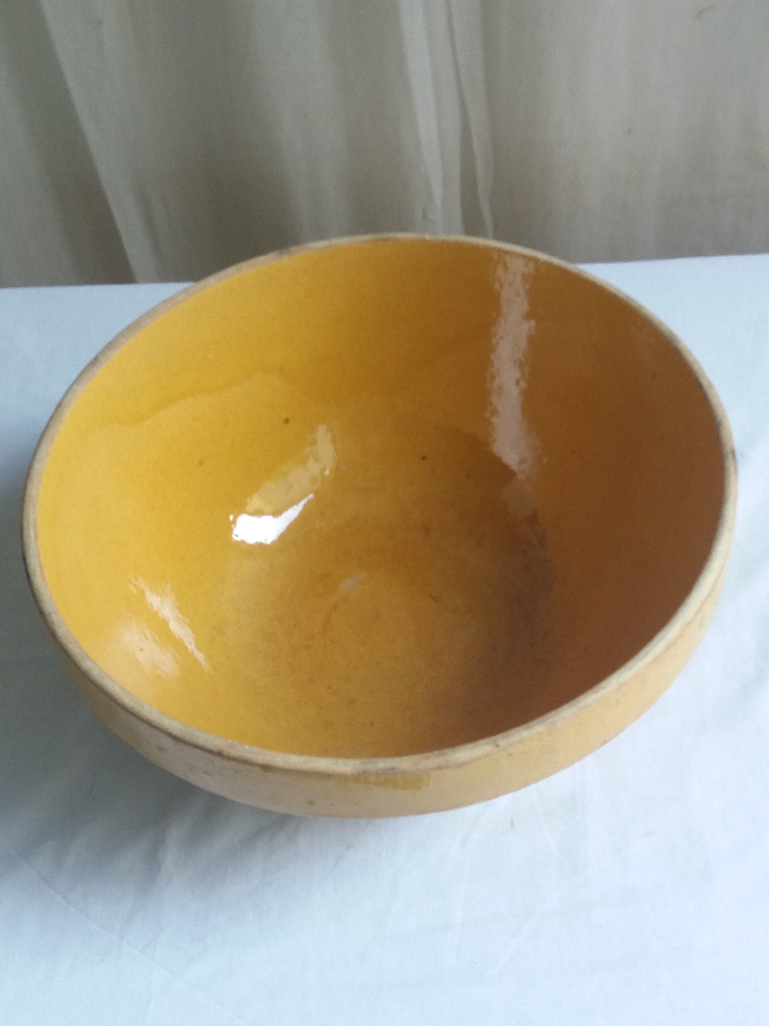 Large old salad bowl in yellow varnished earth