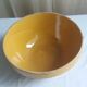 Large old salad bowl in yellow varnished earth