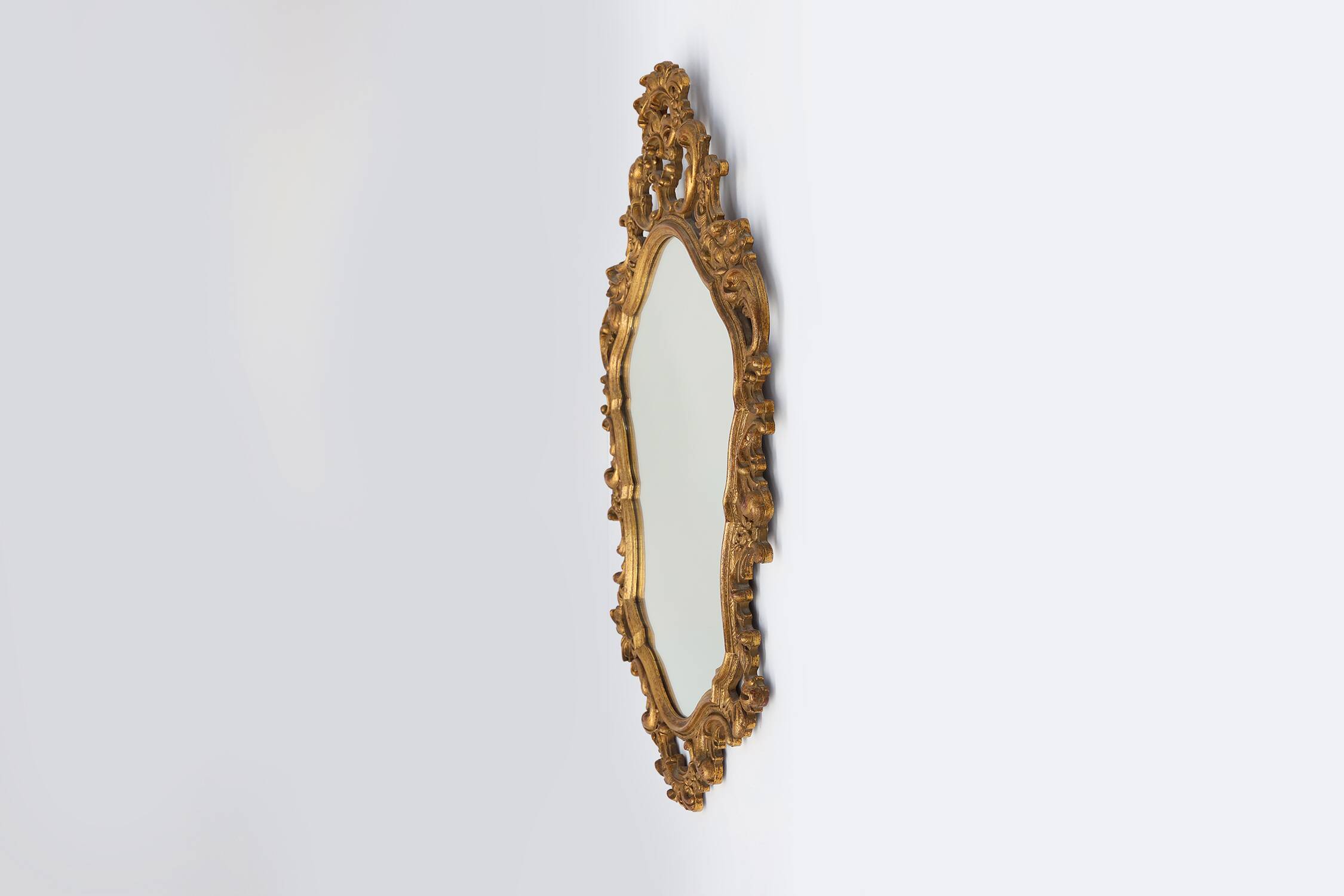 Baroque style oval wall mirror in gilded wood, France