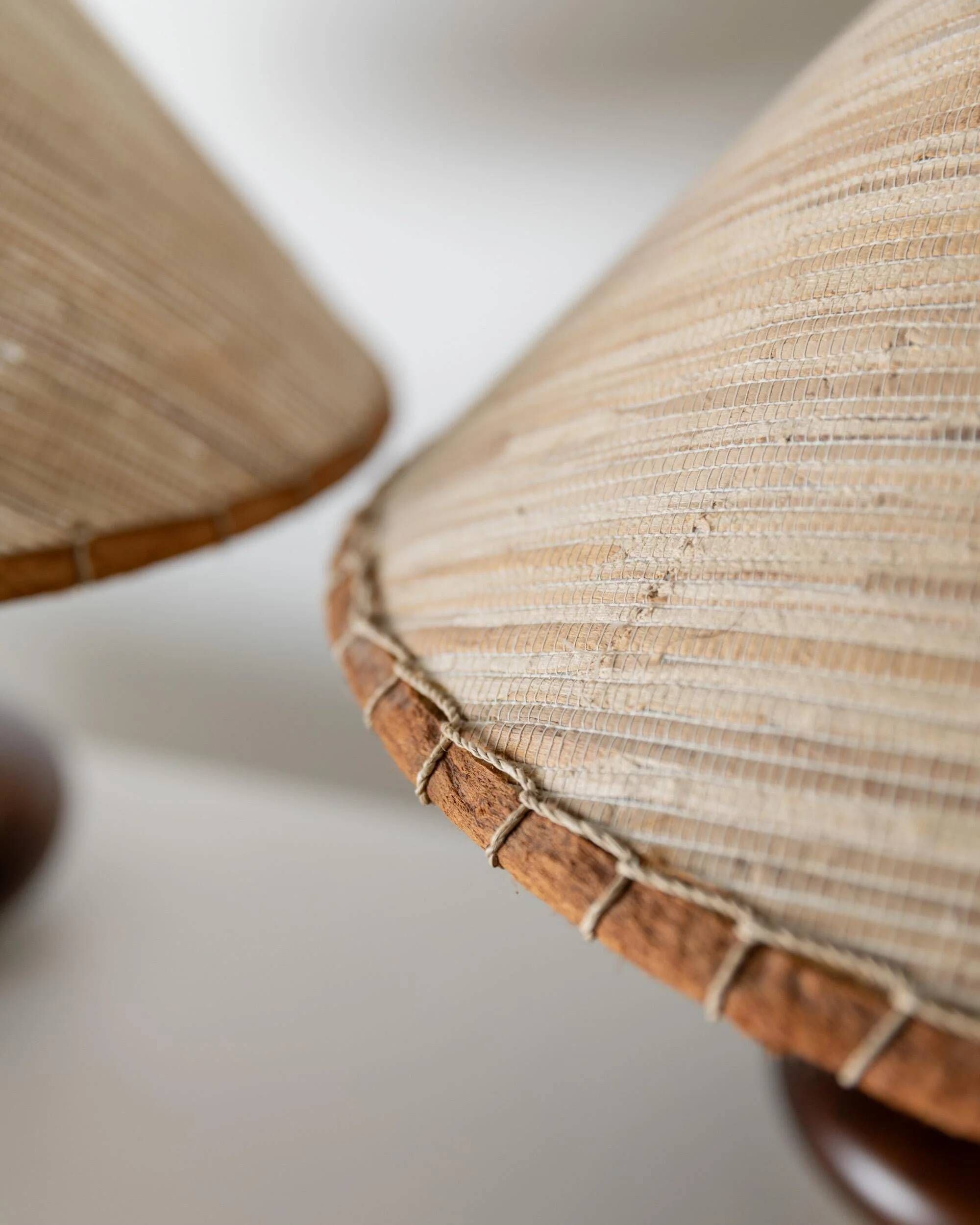 Lot of 2 vintage table lamps from the 1970s, dark wood oval bases with curved brass details, handmade natural fibre lampshades, elegant lighting.