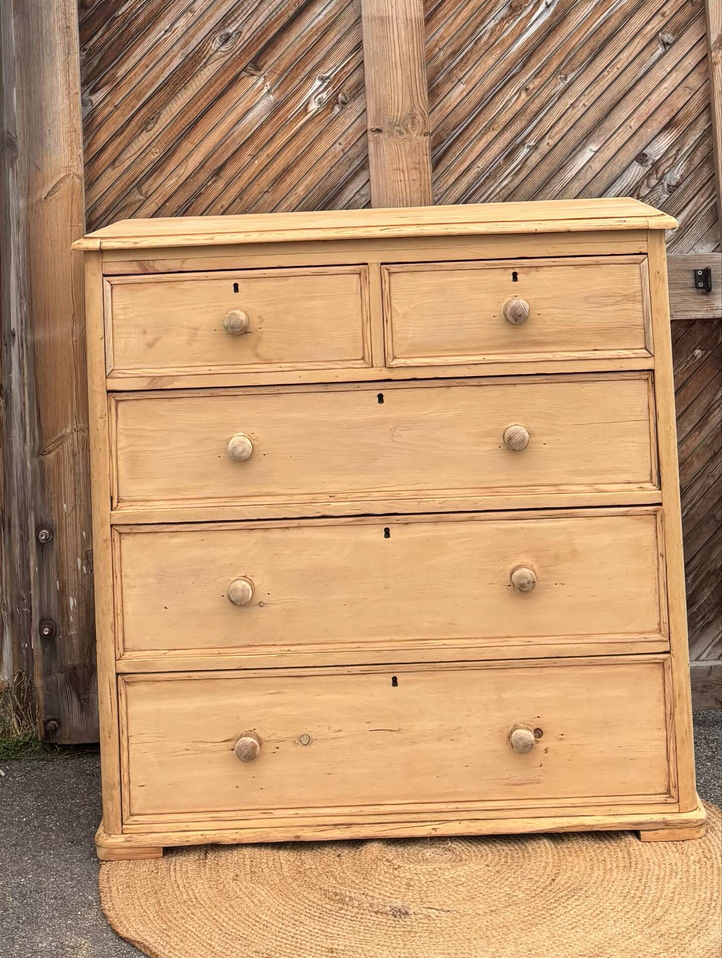Large antique English chest of drawers in raw solid wood.