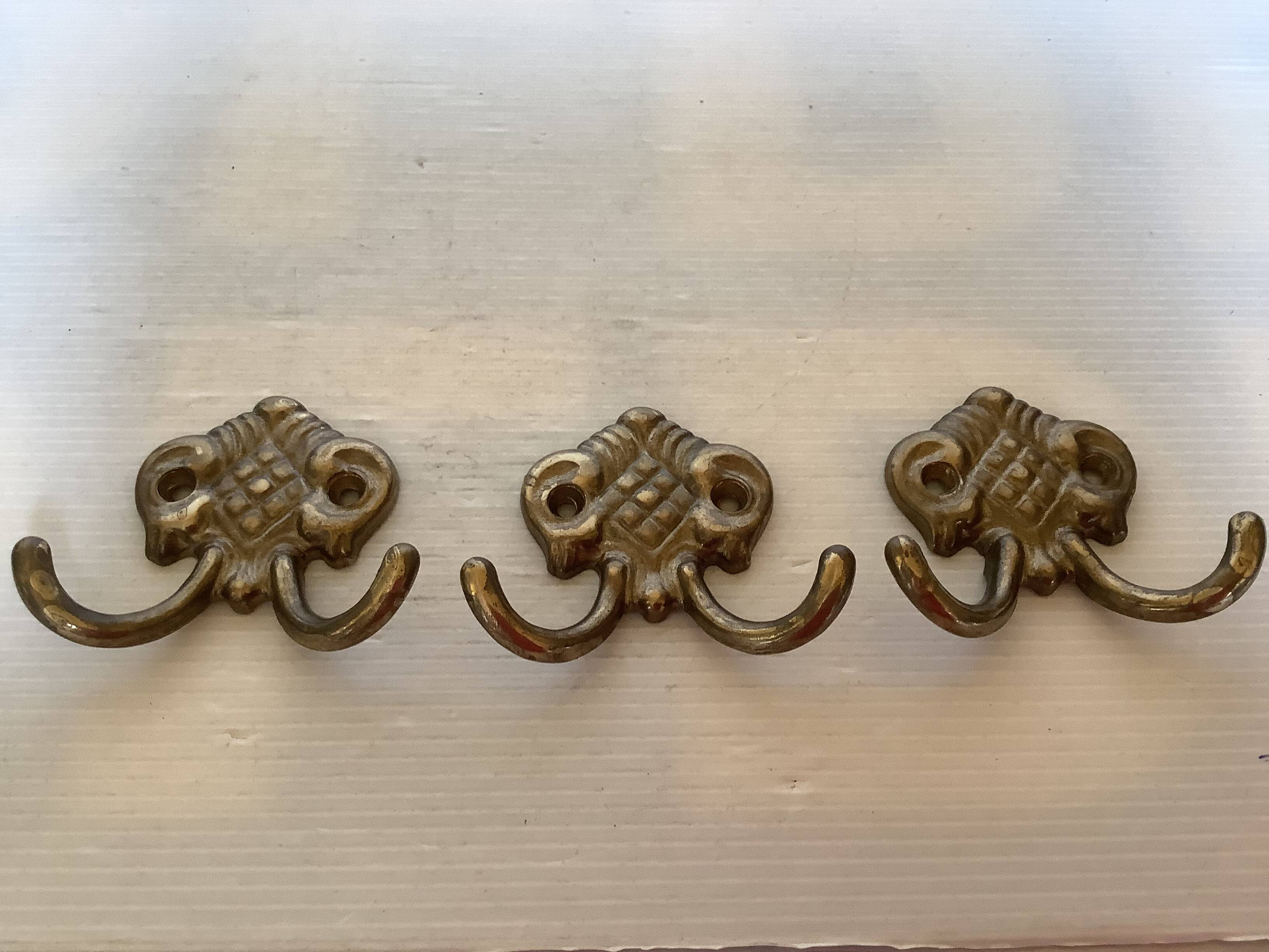 Three double brass coat hooks.