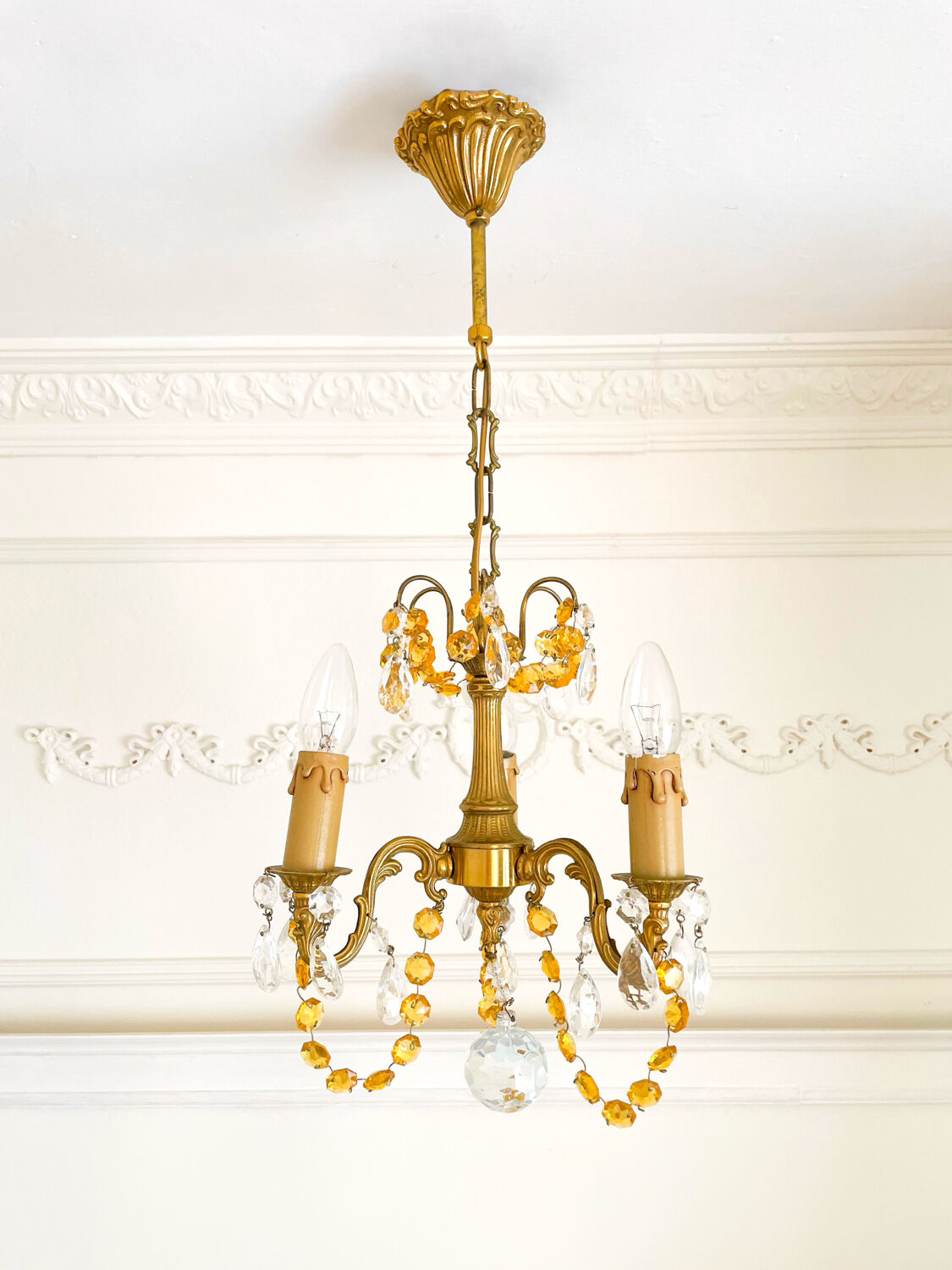 Small vintage brass chandelier with amber crystal pendants.