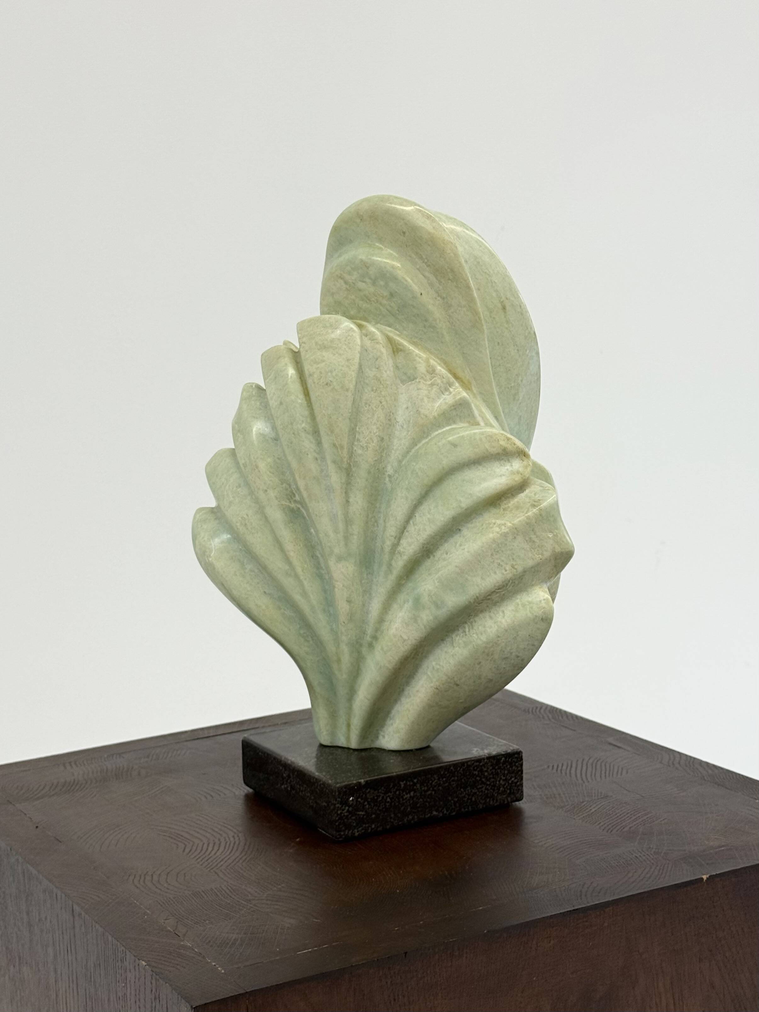 Green natural stone sculpture on marble base