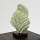 Green natural stone sculpture on marble base