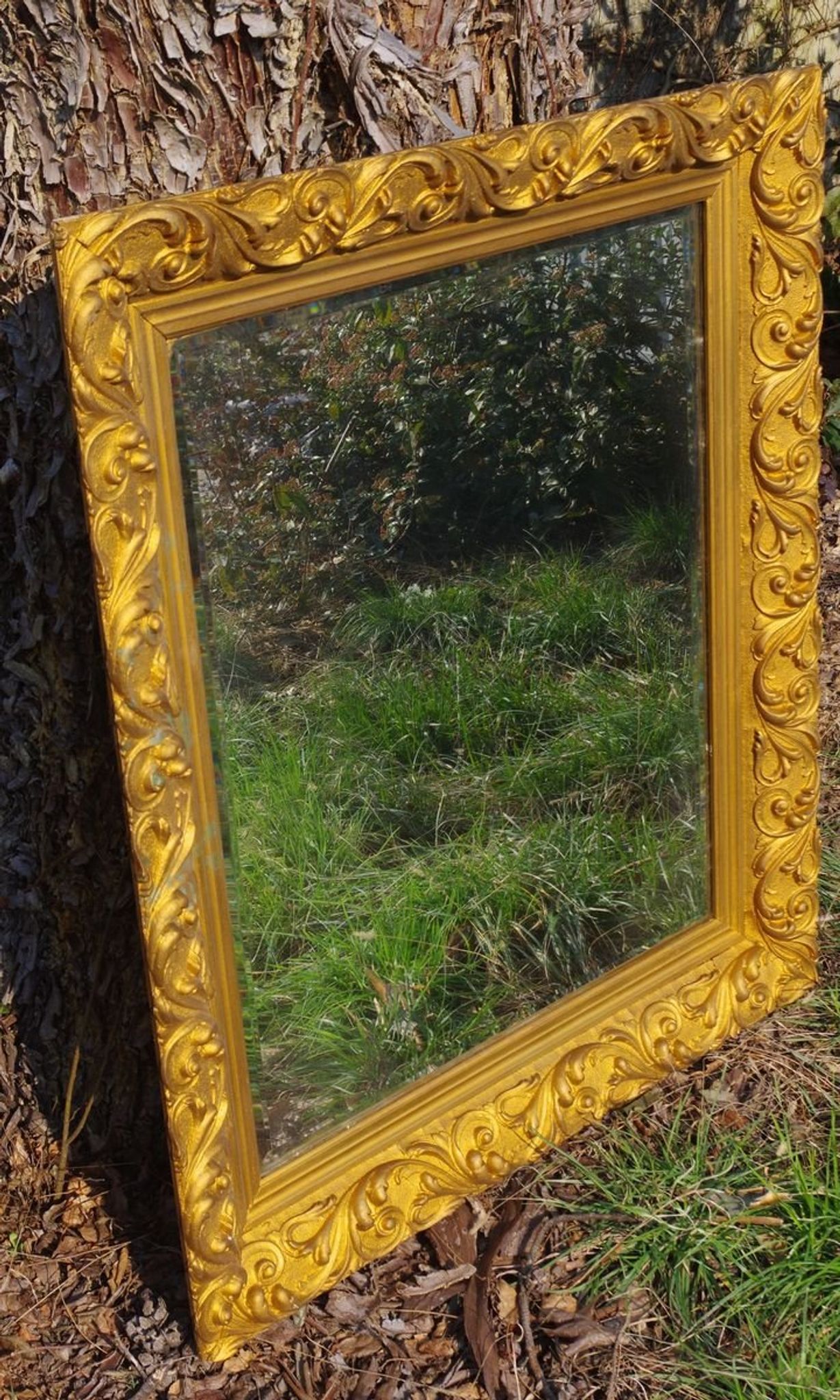 Wooden mirror decorated with gold from the 1920s
