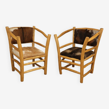 Pair of rustic armchairs in wood and cowhide