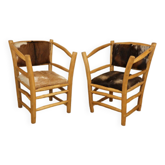 Pair of rustic armchairs in wood and cowhide
