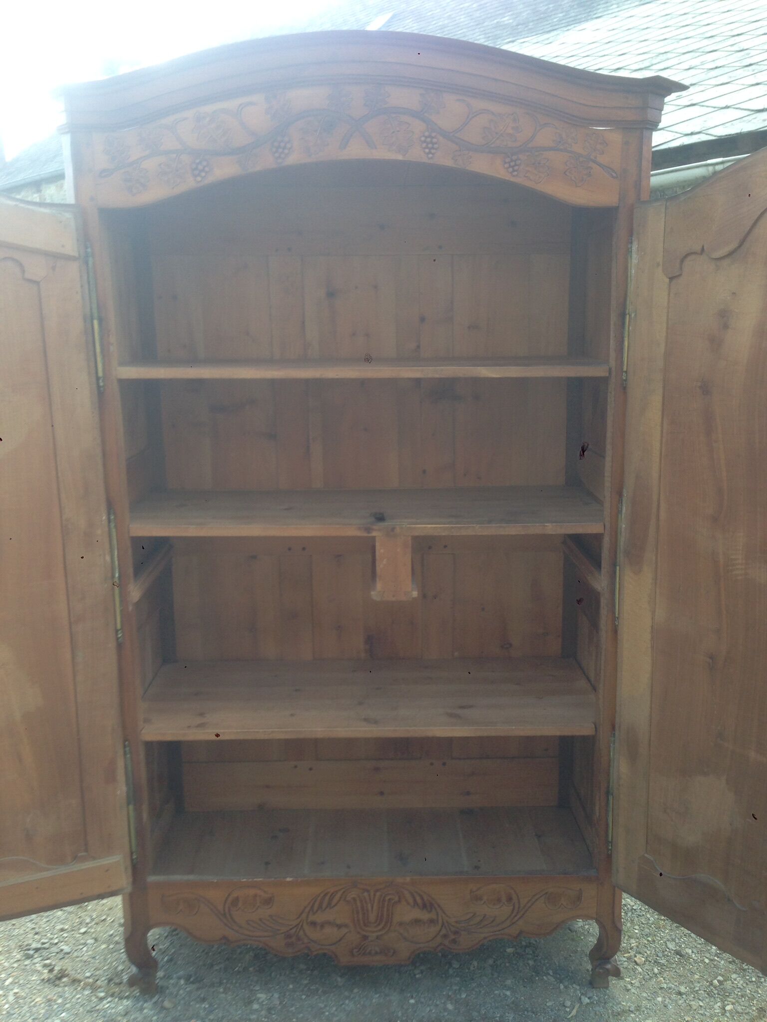 Armoire Louis XV Nantaise sculptée à grappes de raisin, chapeau de gendarme en cerisier fin 19eme.