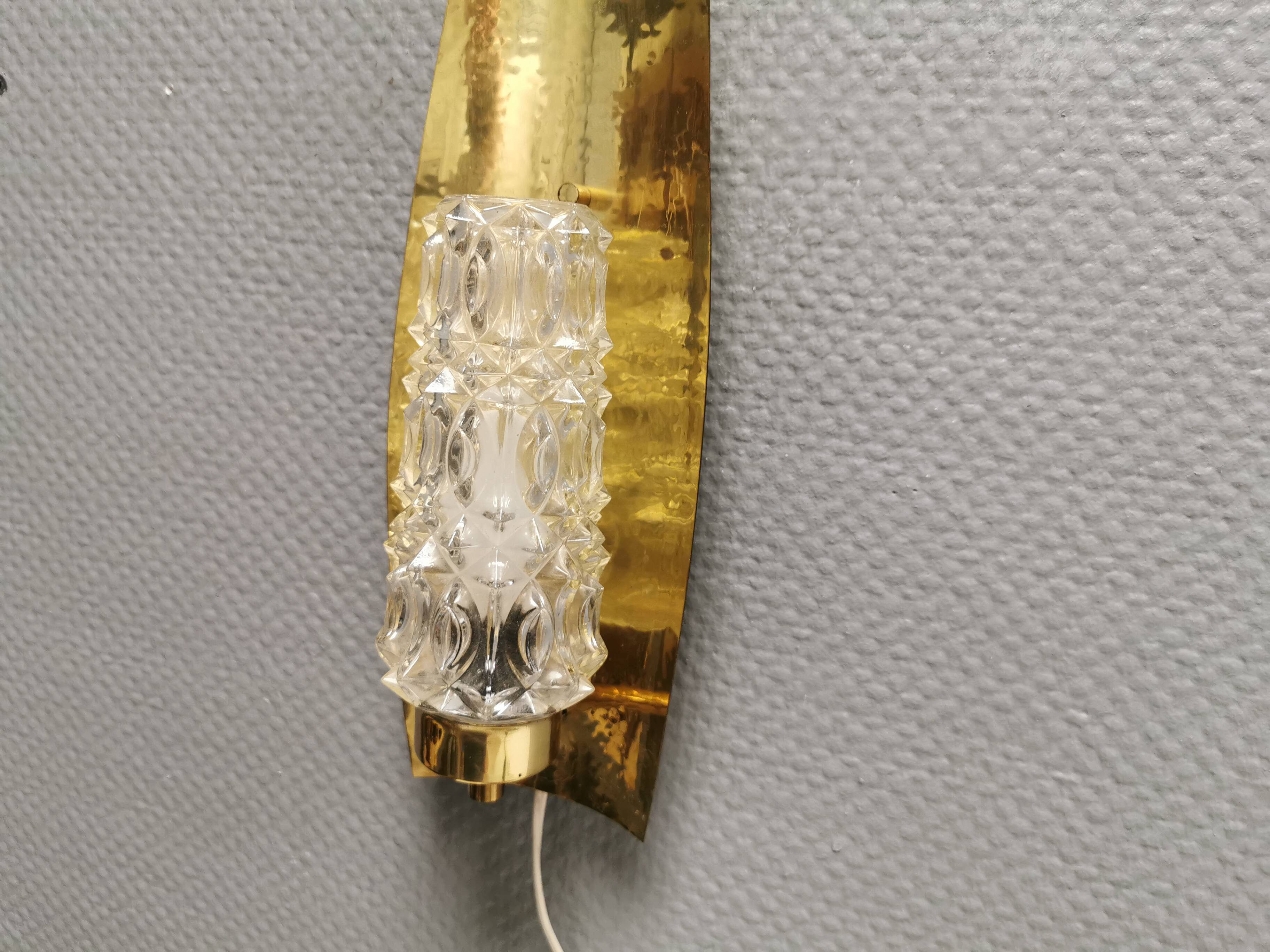 Older wall lamp in brass with hard pressed glass shade.