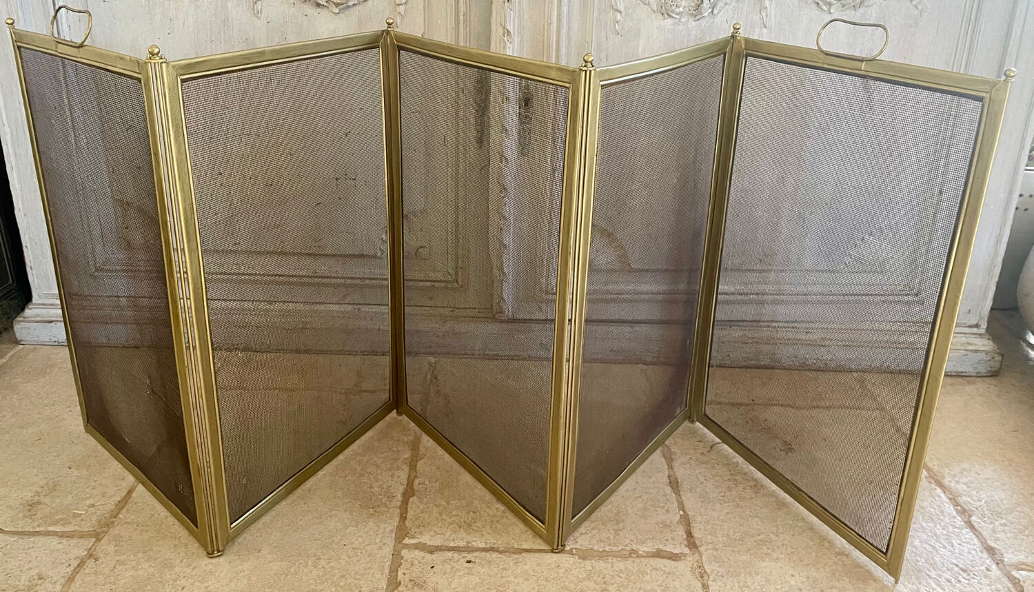 Five-panel golden metal fireplace screen from the 19th century.
