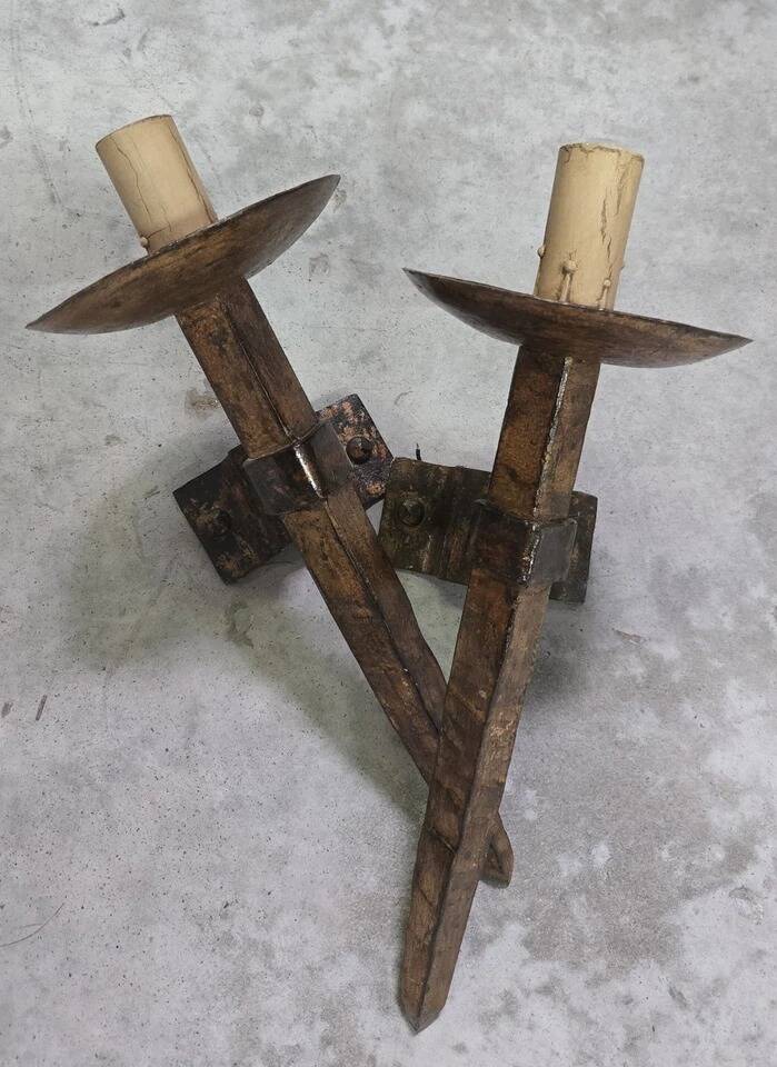 Pair of brutalist wall sconces in hammered and patinated iron, work from the years.