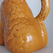 Ancient ceramic pitcher in the shape of a poodle.