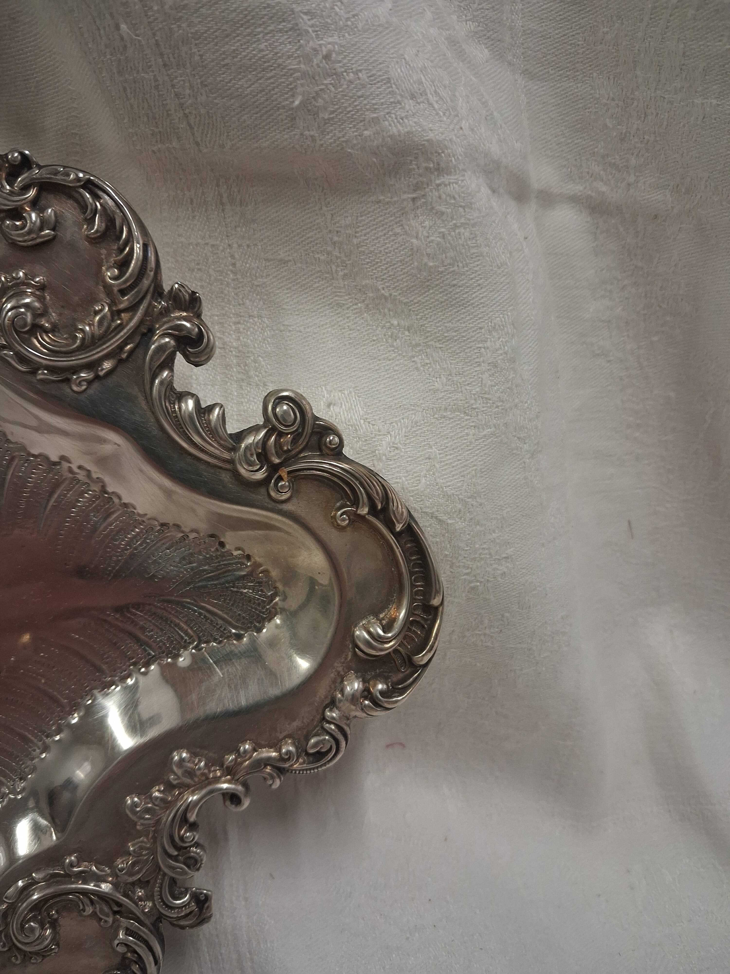 Old small silver-plated tray with a design of scrolls and leaves.
