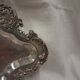 Old small silver-plated tray with a design of scrolls and leaves.