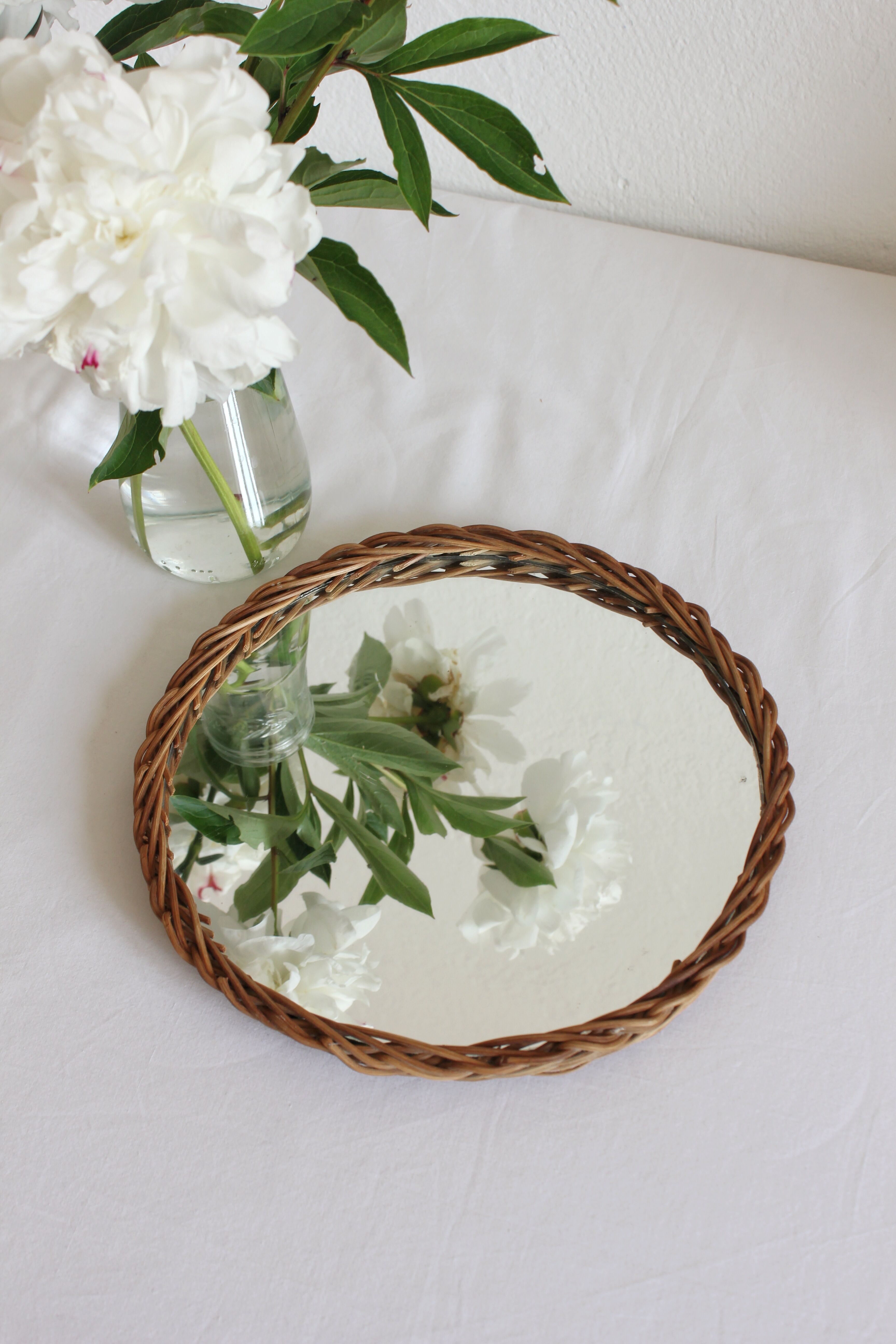 Decorative mirrored tray surrounded by vintage rattan/wicker