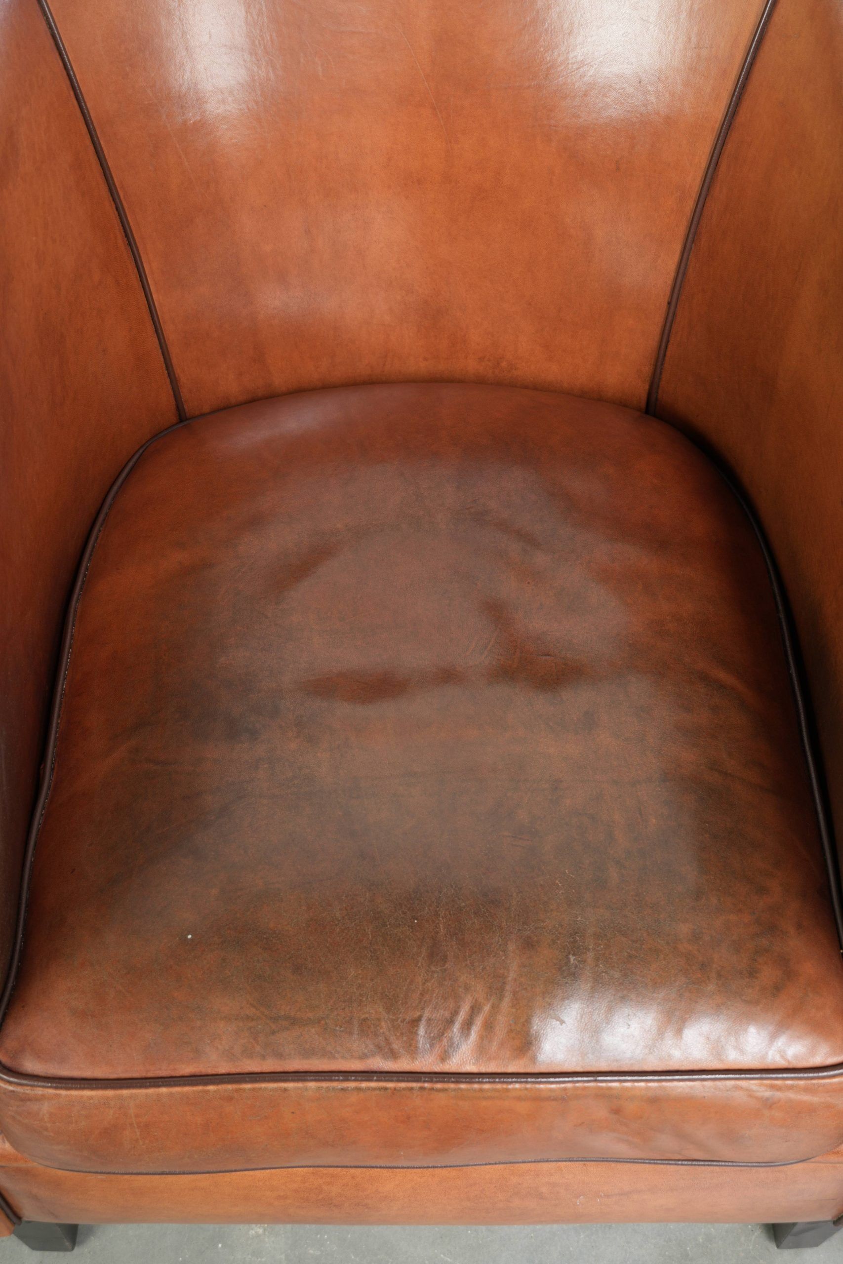 Vintage sheepskin club armchair with a warm colour scheme with black piping