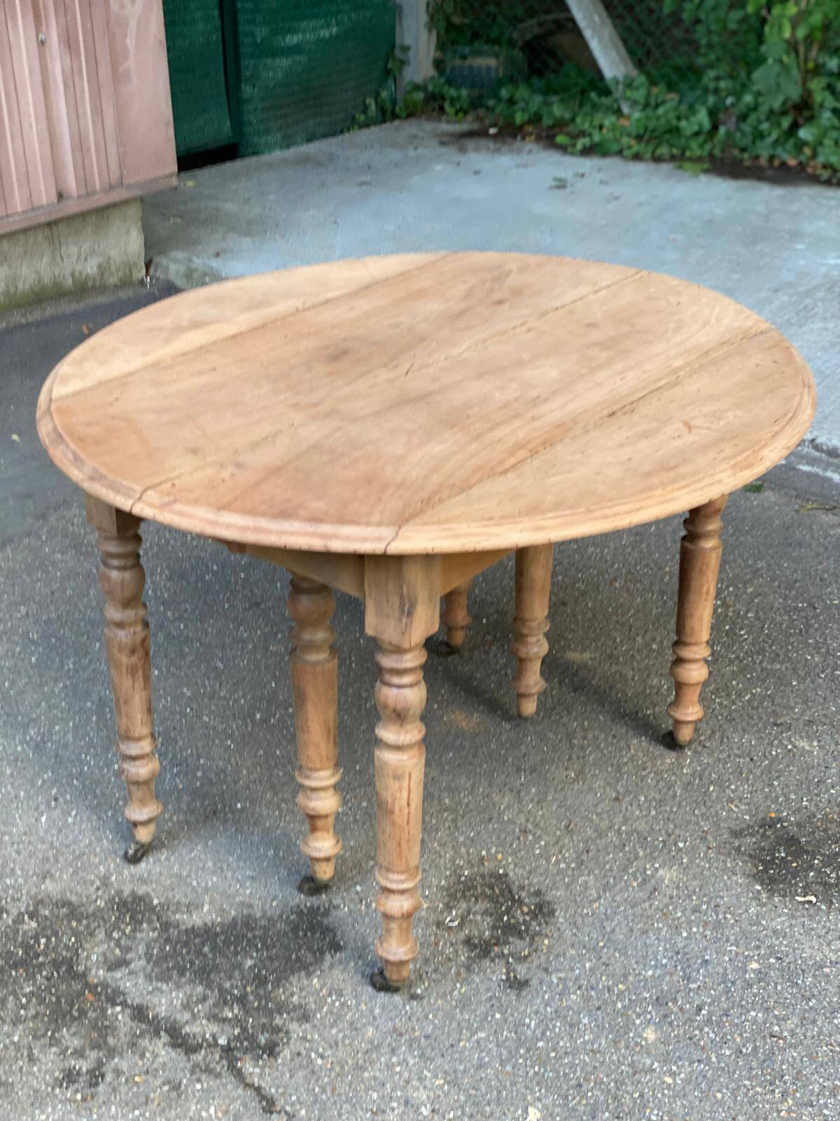 Renovated round extendable dining table with leaves made of solid wood.