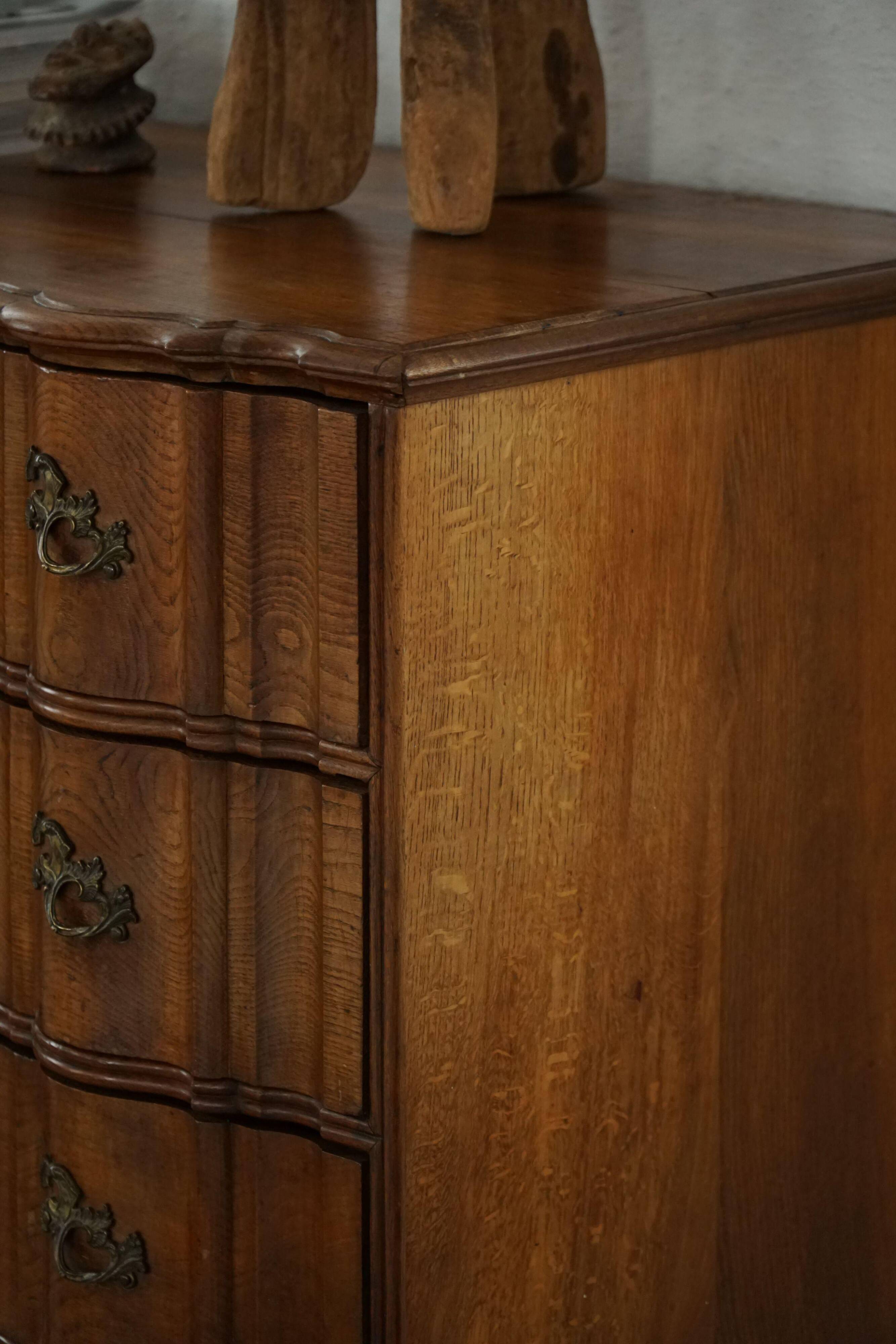 Antique baroque oak commode from the late 18th century with cabriole legs.