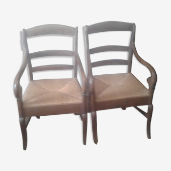 Set of two antique armchairs sitting in straw