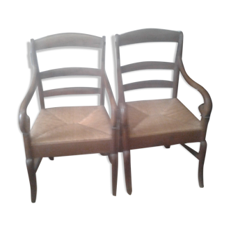 Set of two antique armchairs sitting in straw