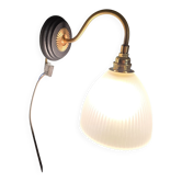 Antique wall sconce in brass and draped glass.