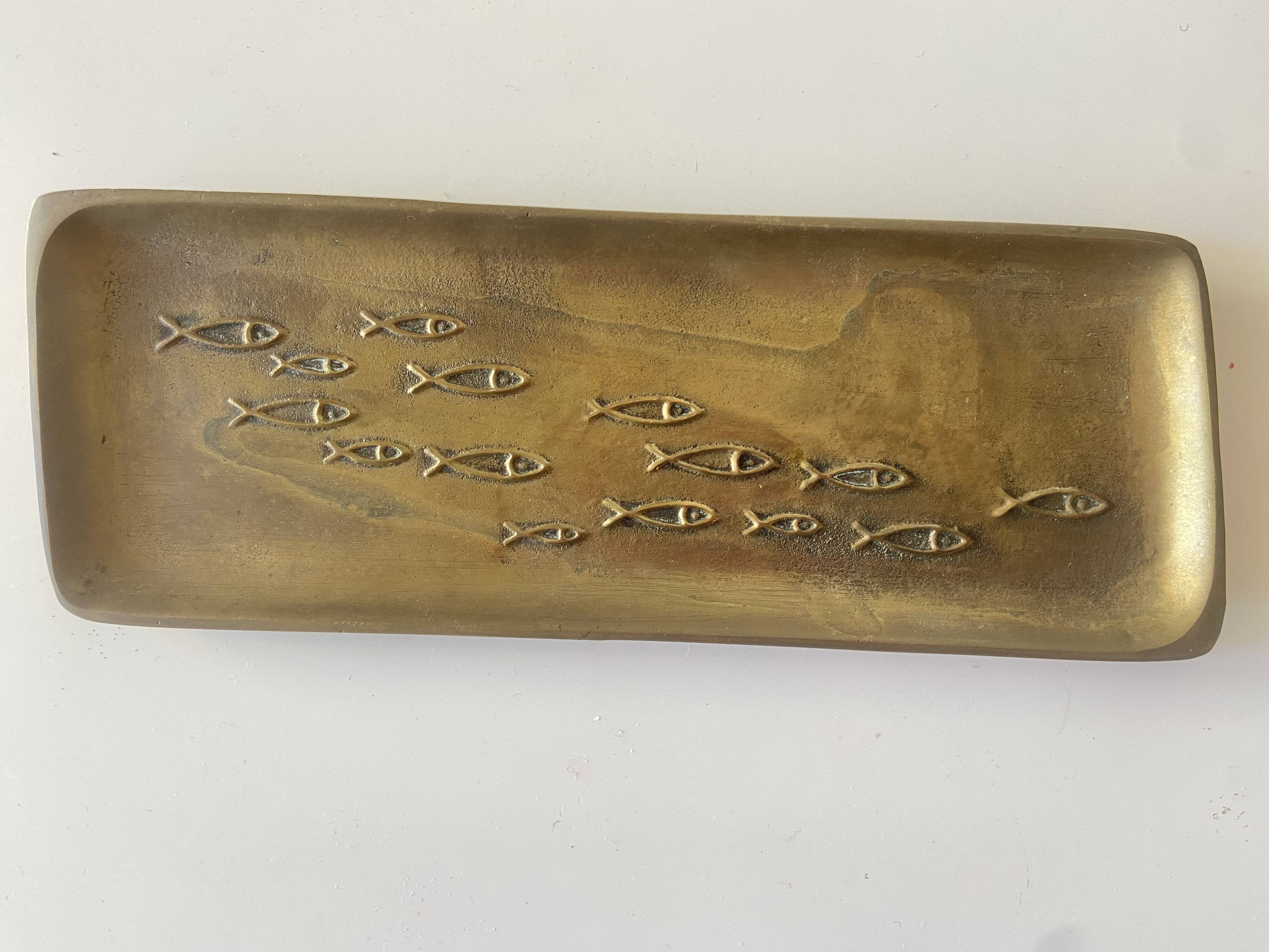 Bronze pocket emptier with fish decoration.