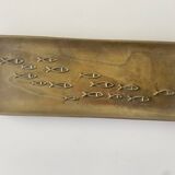 Bronze pocket emptier with fish decoration.