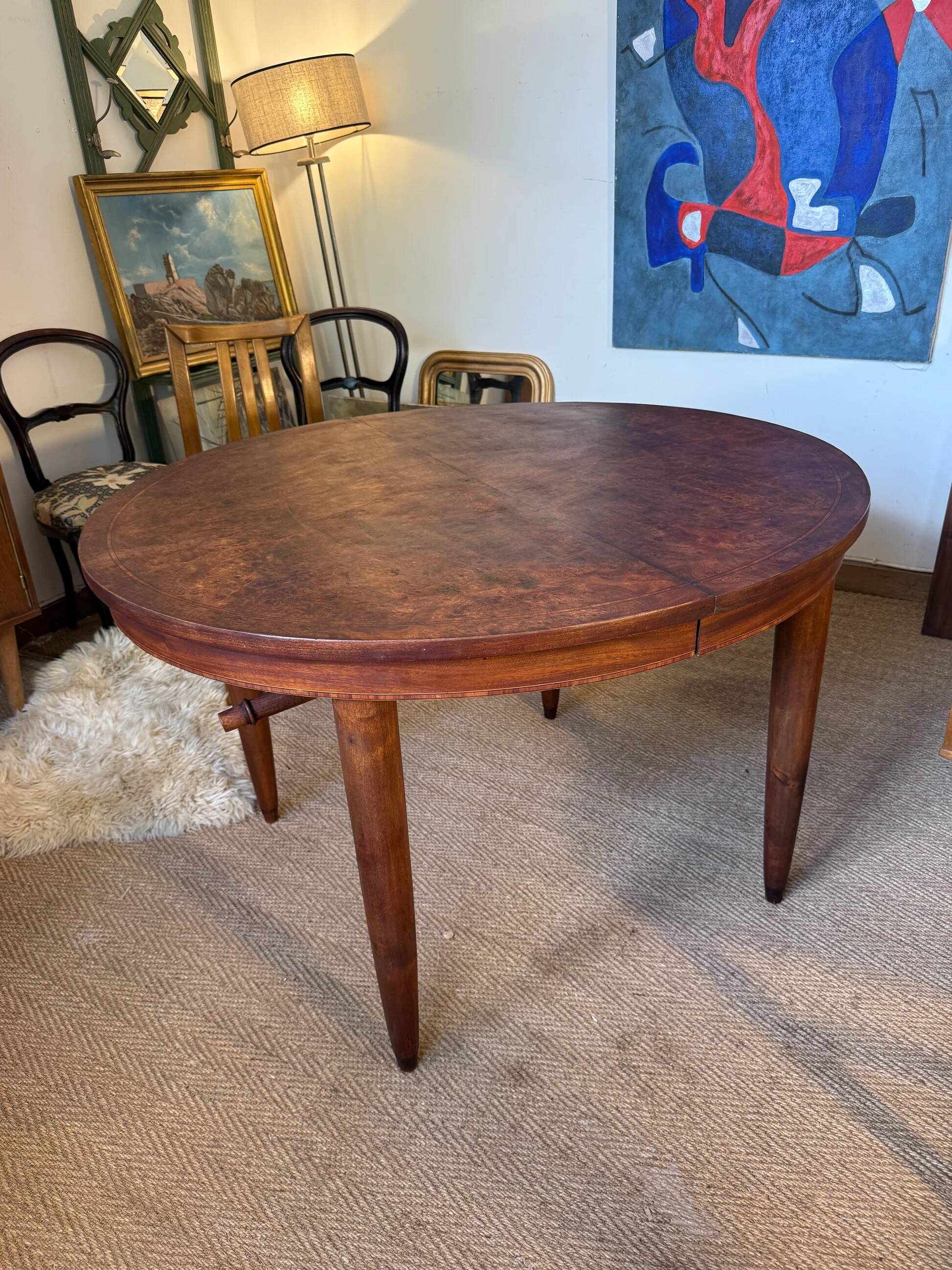 Oval extendable dining table in wood and walnut burl veneer.