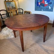 Oval extendable dining table in wood and walnut burl veneer.