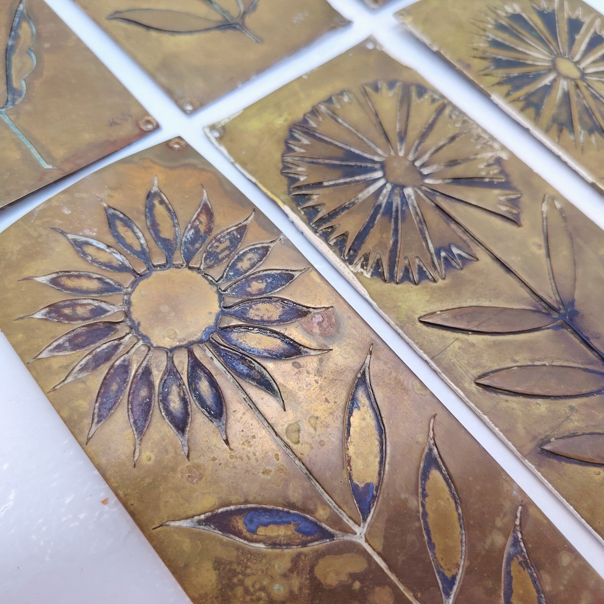 Six cleanliness plaques, flower design, brass.